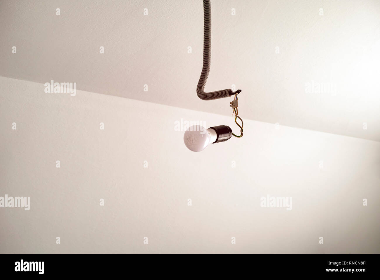 Light Bulb Hanging On The Wire On The Ceiling Close Up Stock