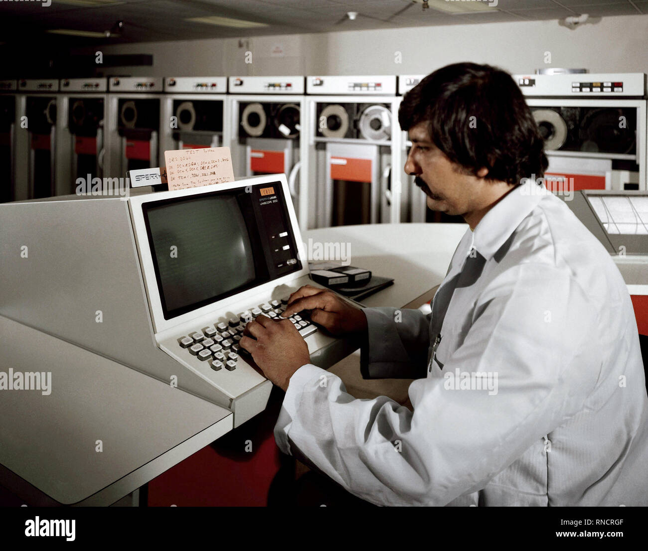 1981 - A technician operates the system console on the new UNIVAC 1100/83 computer at the Fleet Analysis Center, Corona Annex, Naval Weapons Station, Seal Beach, California. Stock Photo