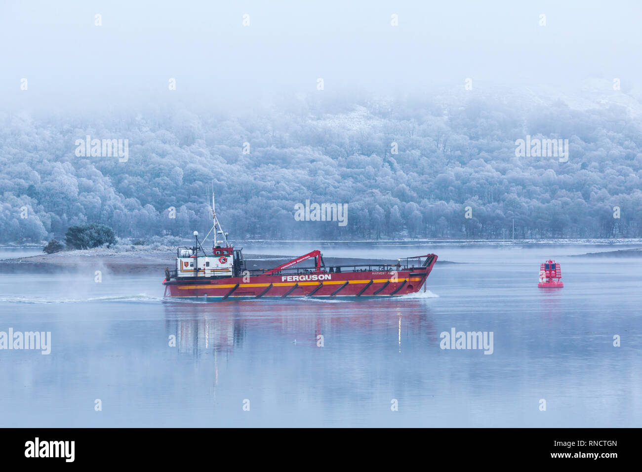 Ferguson transport & shipping vessel Harvest Anne motoring on a cold winter morning with frost and fog at Corpach, Fort William, Scotland in February Stock Photo