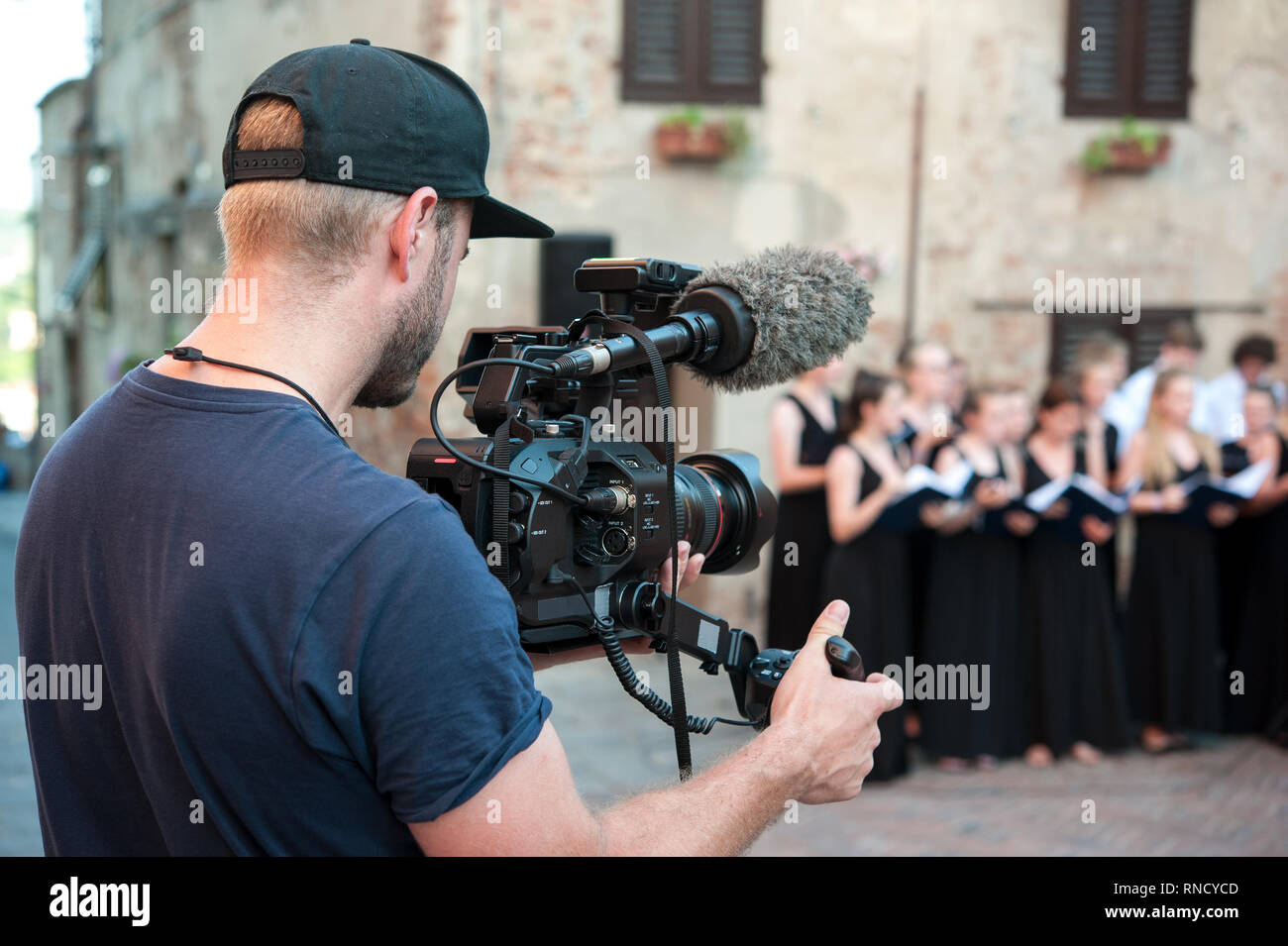 Cameraman captures video and audio whit professional video camera, during a choir live concert Stock Photo