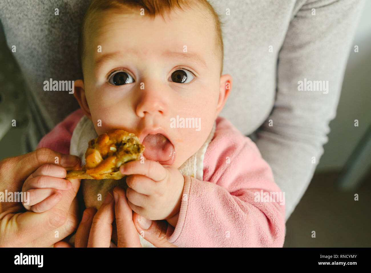 5 month old baby eating a chicken leg using the Baby led weaning BLW method  Stock Photo - Alamy