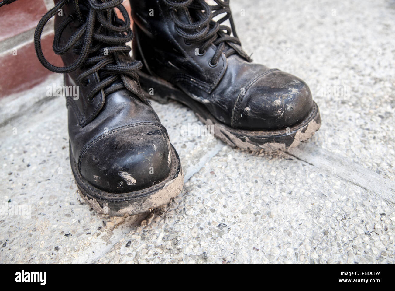 Muddy and dirty black boots day after metal music festival Stock Photo -  Alamy