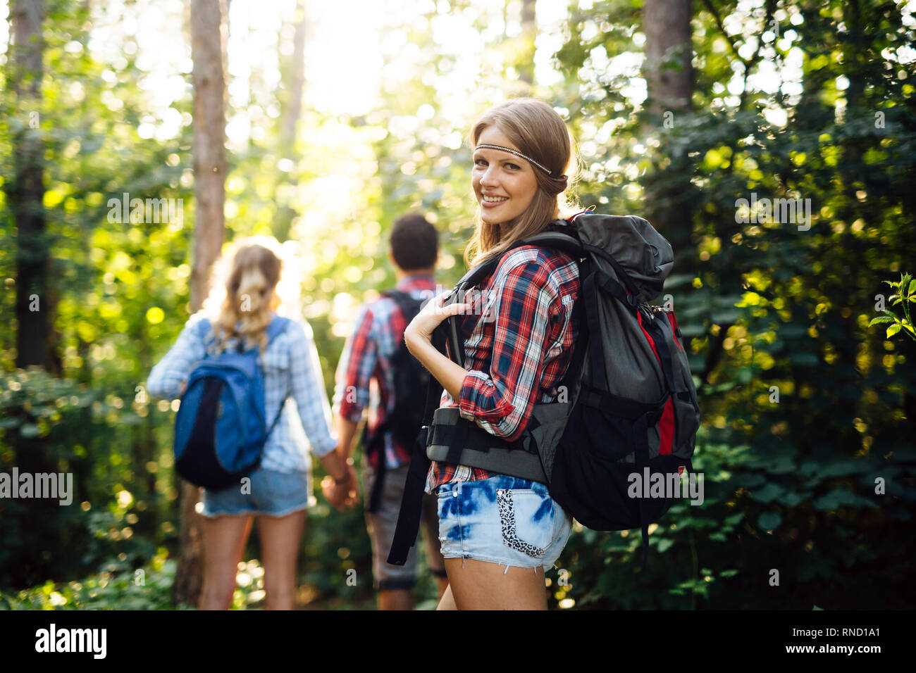 Group of backpacking hikers going for forest trekking Stock Photo - Alamy