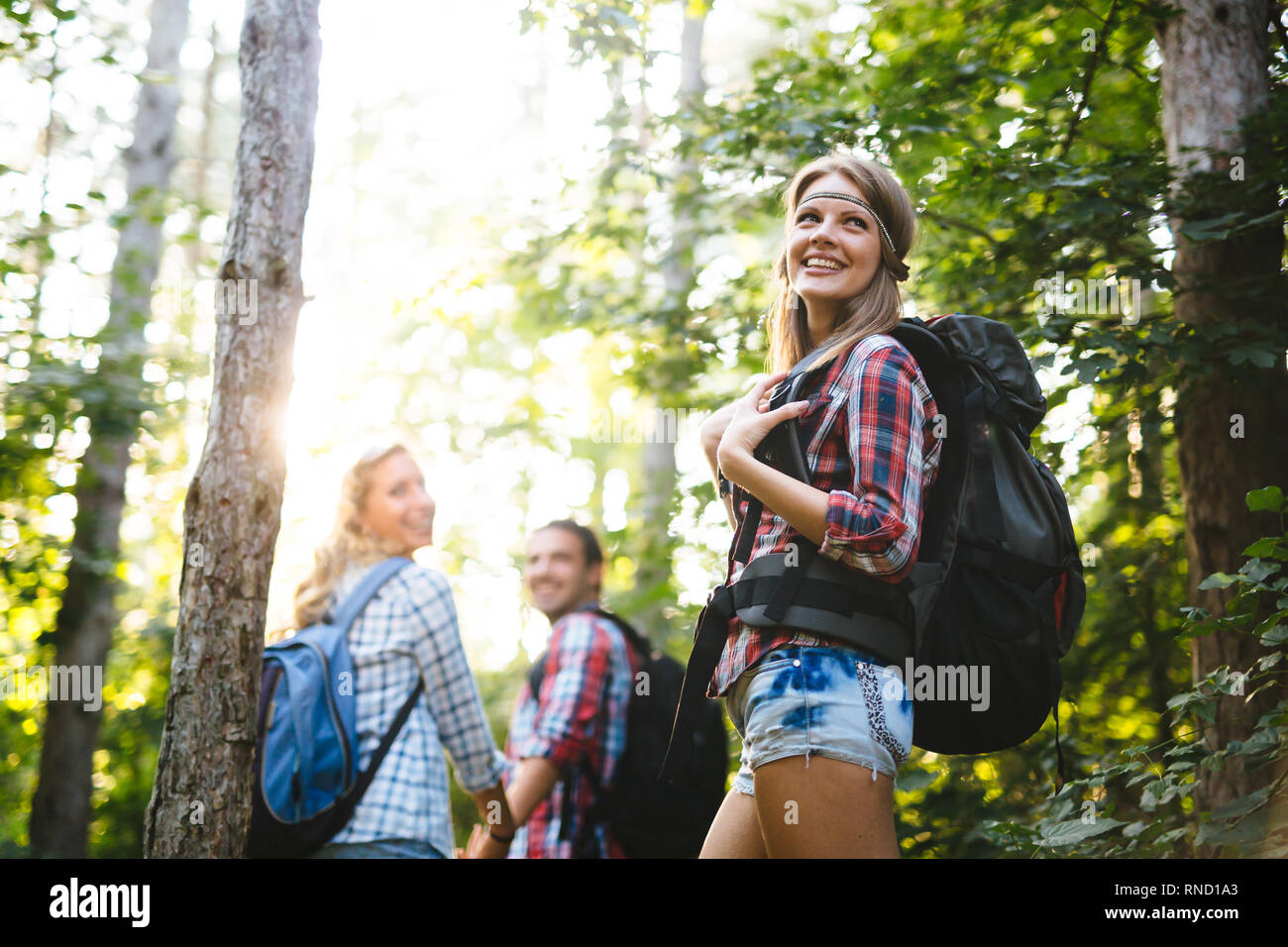Beautiful woman and friends hiking in forest Stock Photo - Alamy