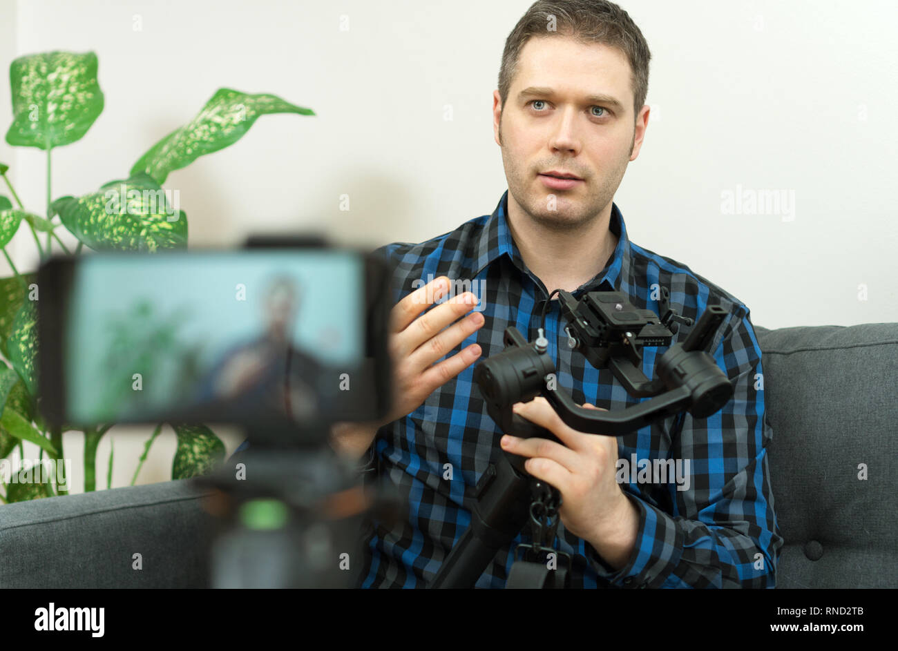 Handsome man making video blog about handheld camera stabilizer. Stock Photo