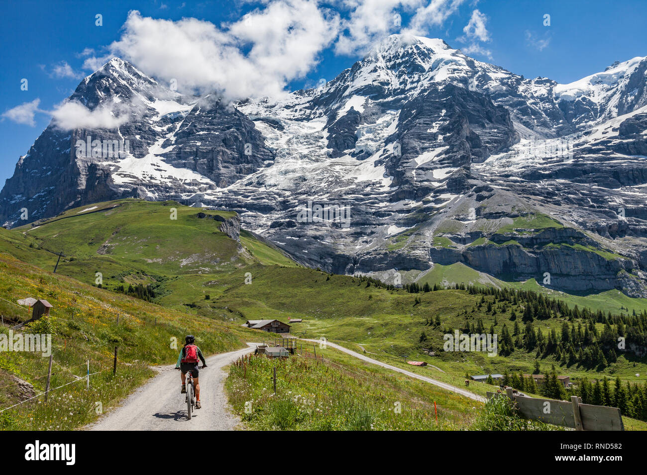 nice and ever young senior woman riding her e-mountainbike below the Eiger northface, Jungfrauregion, Switzerland Stock Photo