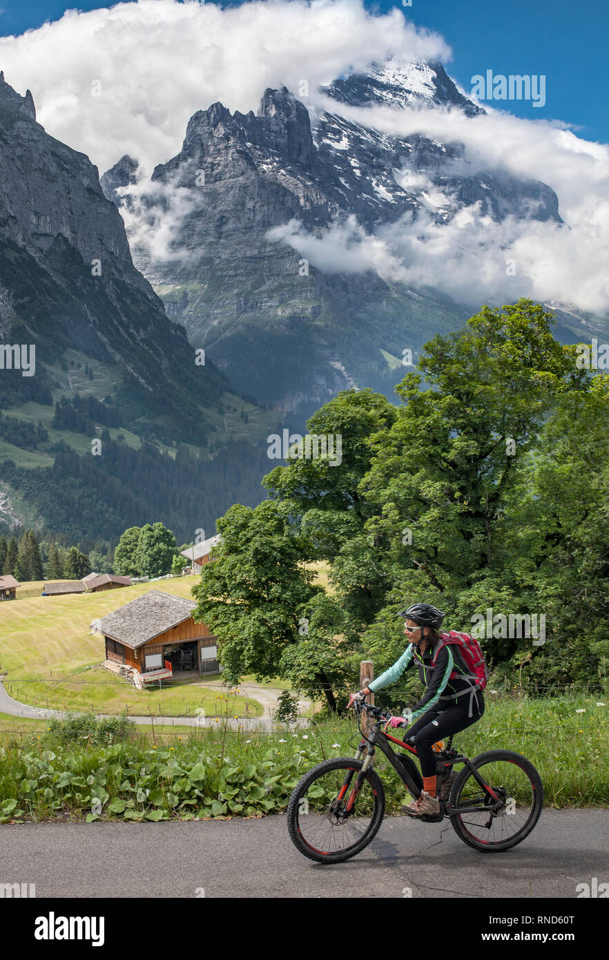 nice and ever young senior woman riding her e-mountainbike below the Eiger northface, Jungfrauregion, Stock Photo