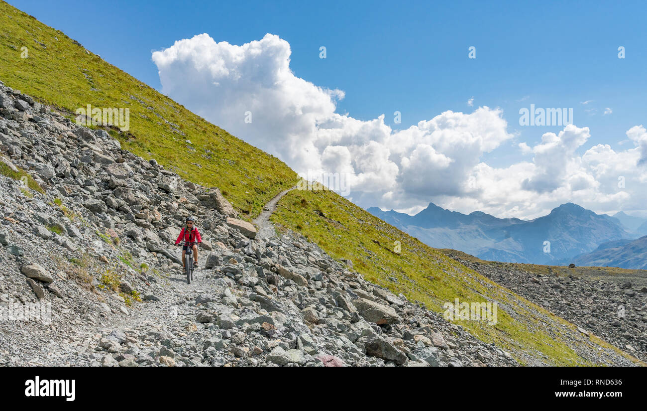 active senior woman, riding her e-mountainbike on the famous Suvretta Loop trail, high above Saint Moritz, Engadin, Switzerland Stock Photo