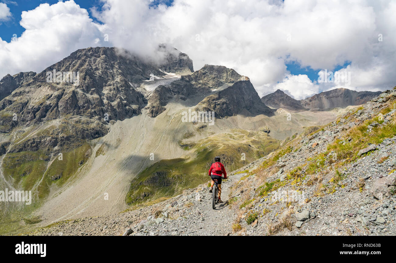 active senior woman, riding her e-mountainbike on the famous Suvretta Loop trail, high above Saint Moritz, Engadin, Switzerland Stock Photo