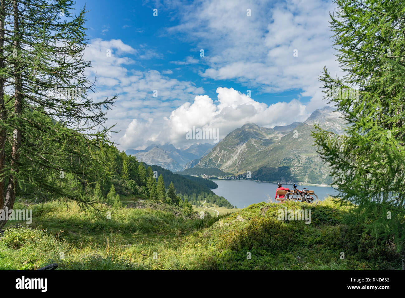 Senior woman, riding here e-mountain bike on the famous trails around the lakes in the upper Engadin, between Saint Moritz and Maloja, Switzerland Stock Photo