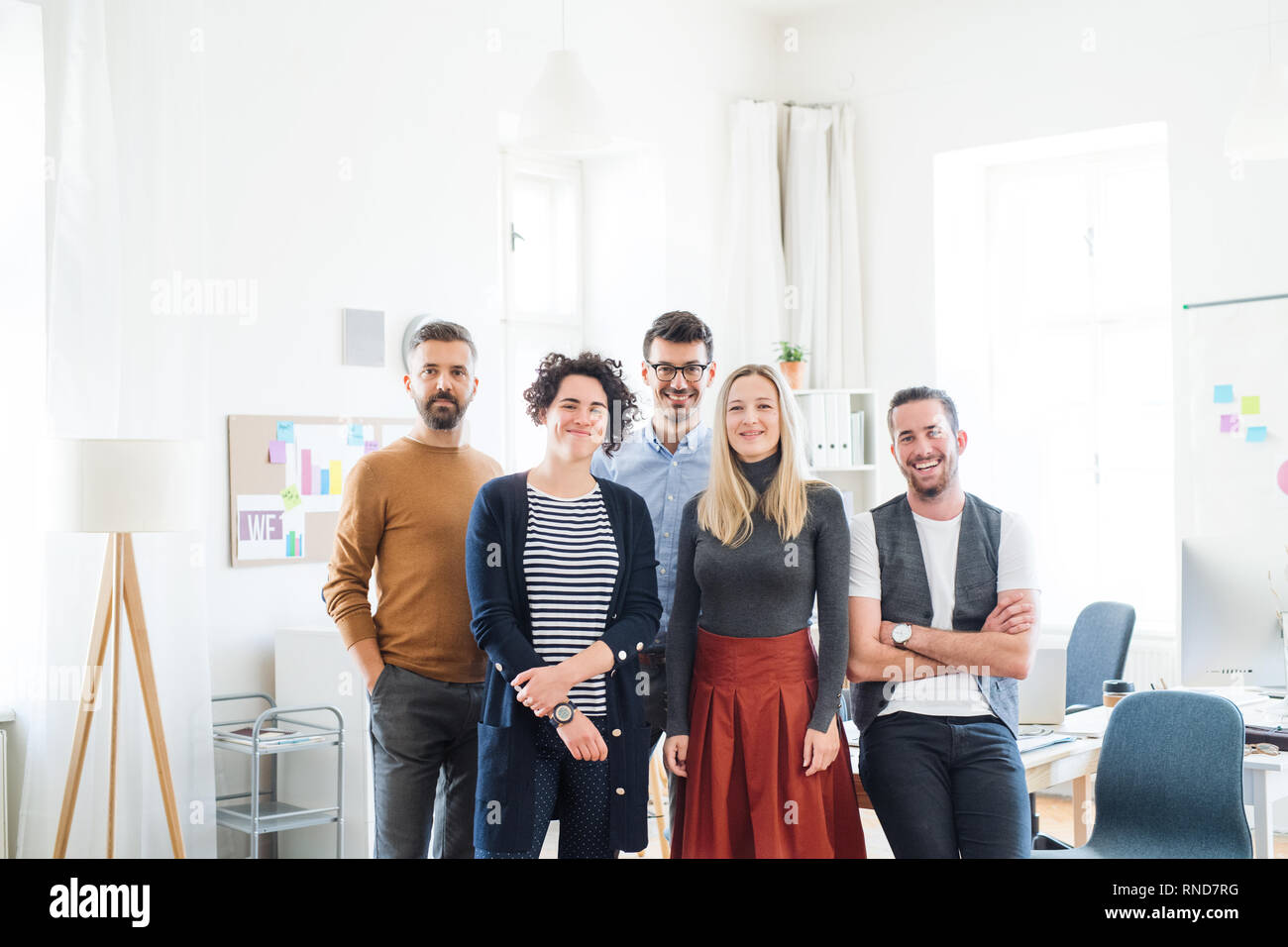 A portrait of group of young businesspeople standing in a modern office ...