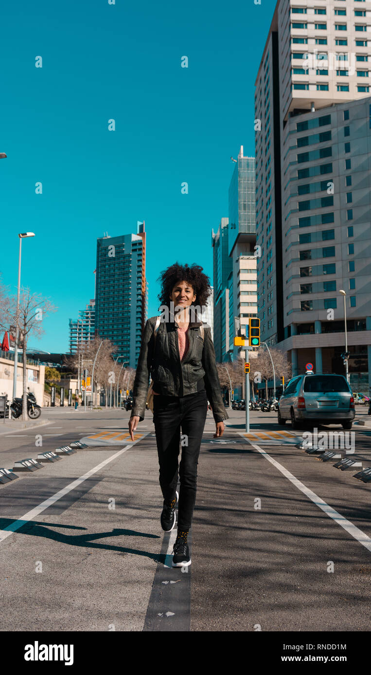 Woman with afro hair walking through the streets of a big city Stock ...