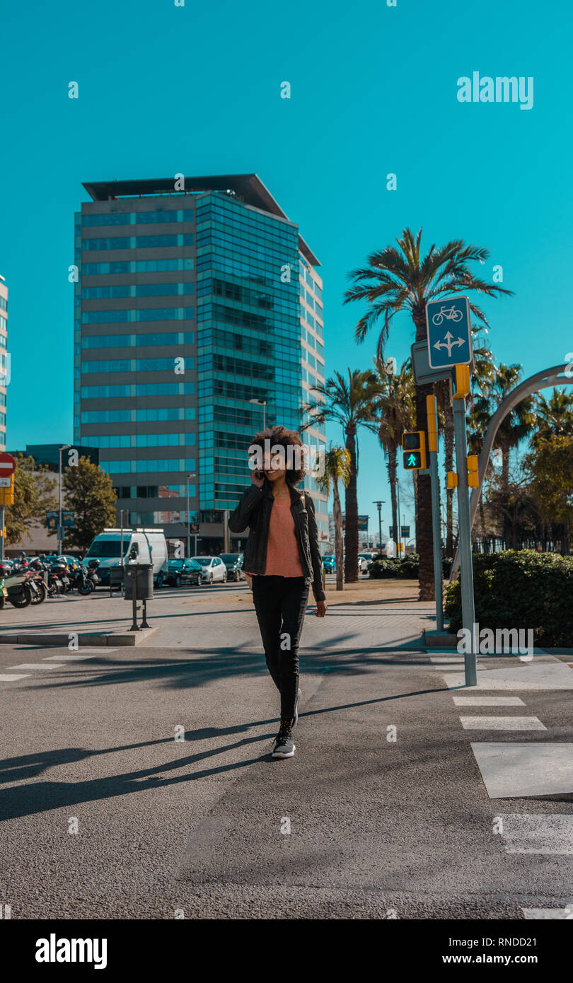 Woman with afro hair walking through the streets of a big city Stock ...