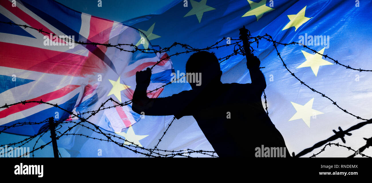 Brexit, immigration, asylum seeker... concept image. Rear view of man looking through barbed wire fence under EU flag and Union Jack flag. Stock Photo