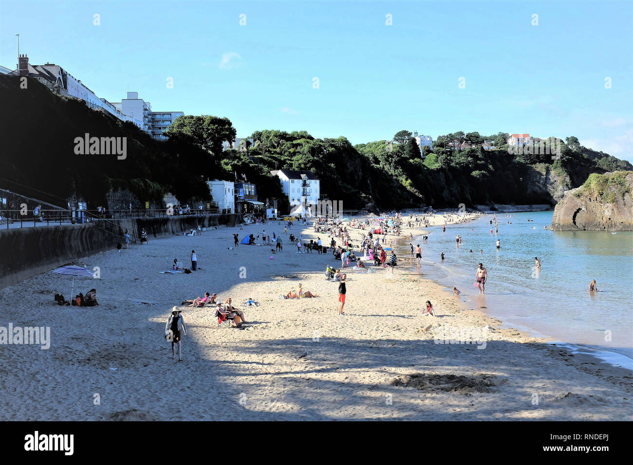 Tenby, Pembrokeshire, South Wales, UK. July 25, 2018.  Tourists and holidaymakers enjoying the North beach and sea at high tide in July at Tenby in So Stock Photo