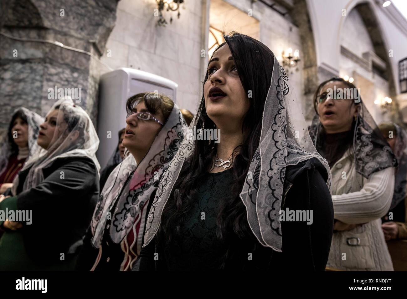 Believers at the Sunday service in the St. George church in the Christian Bartella in front of the gates of Mossul. The Christian population was expelled, but returned to their homes in large numbers. Some churches could be rebuilt, so that church services can take place there again. Nevertheless, the Christians are now threatened by the Shiite conquerors of the province of Ninawa and the capital Mossul, and are being repressed more and more, so that the Christians do not have good prospects for a further life in Bartella. Stock Photo