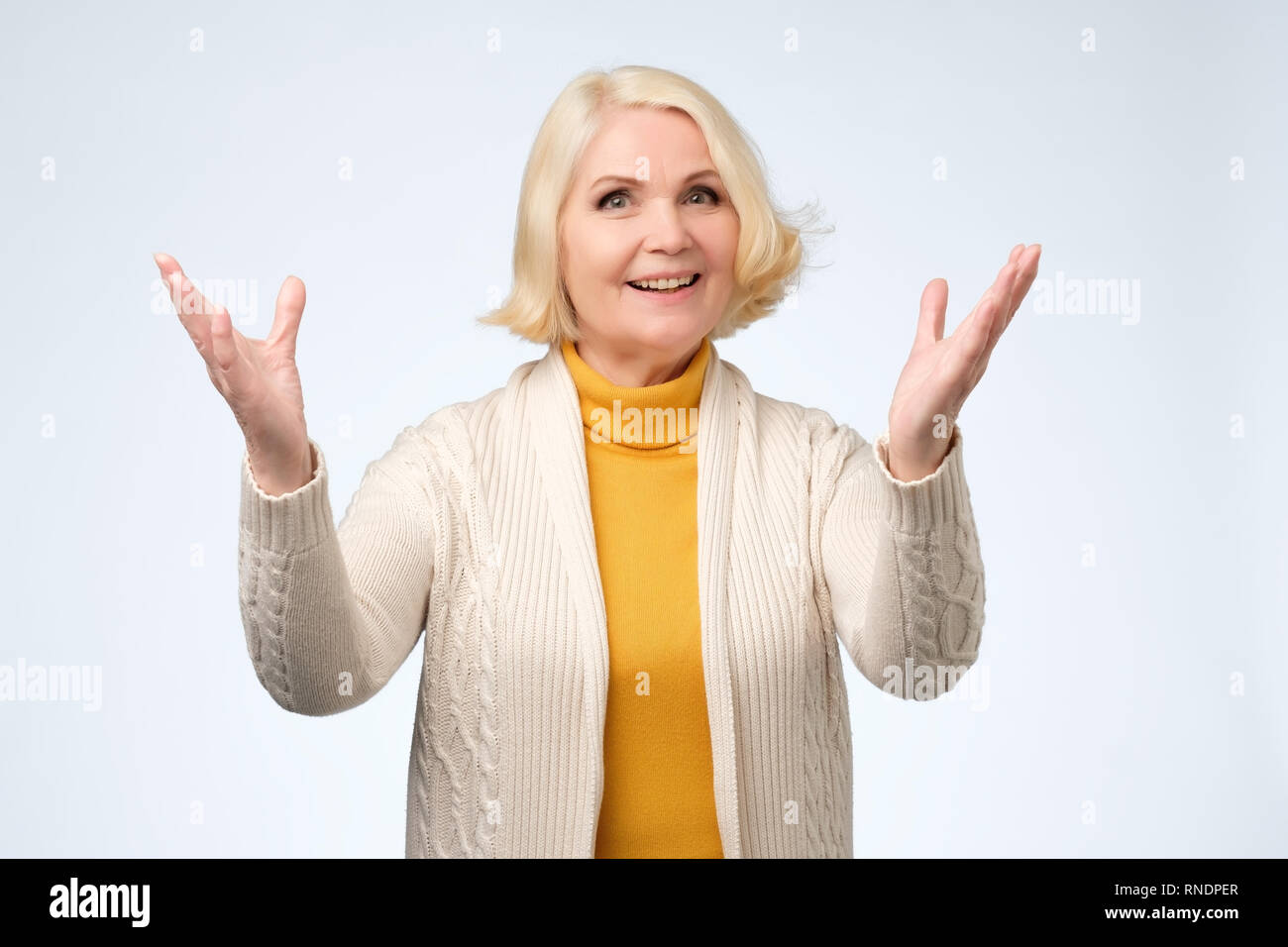 Old adult blonde excited cheerful astonished lady smiling, laughing Stock Photo