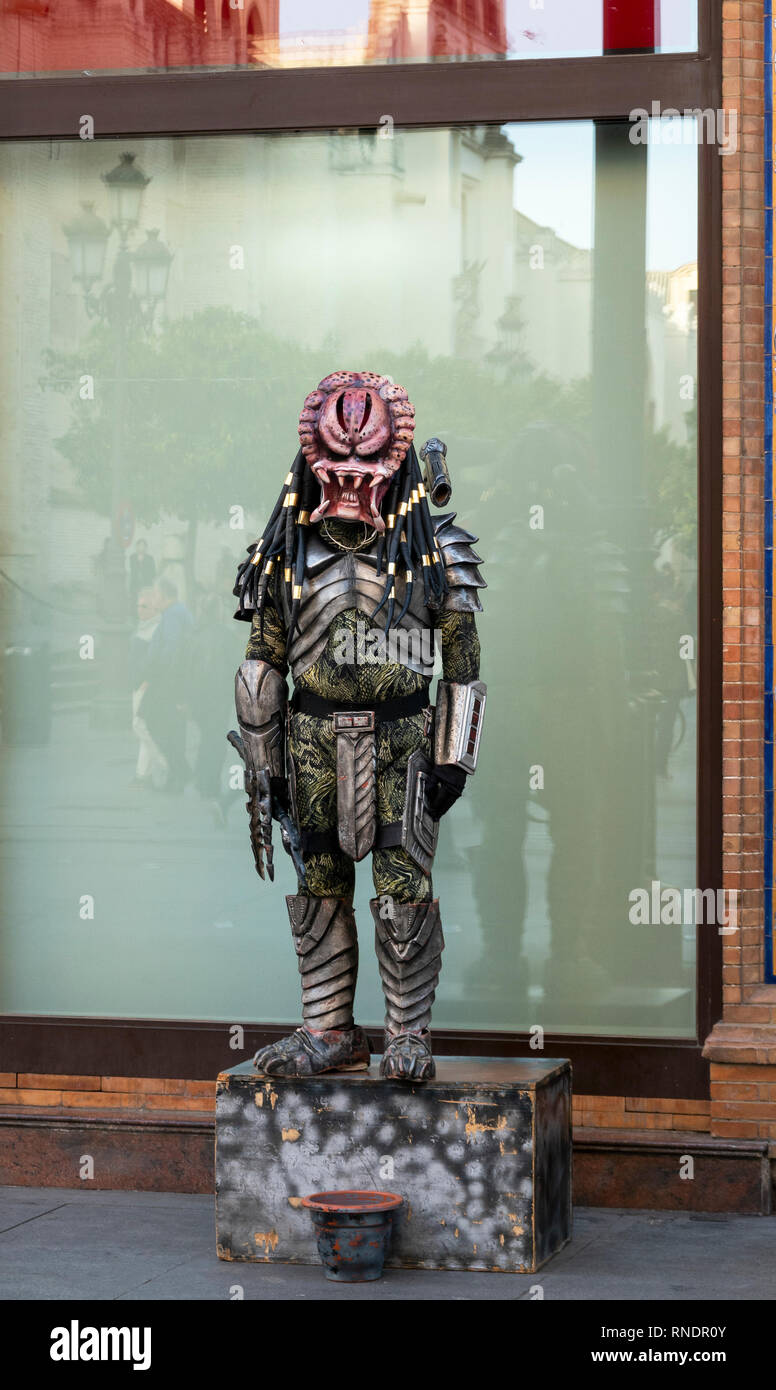 Street performer dressed up as an alien Predator in Seville, Spain Stock Photo