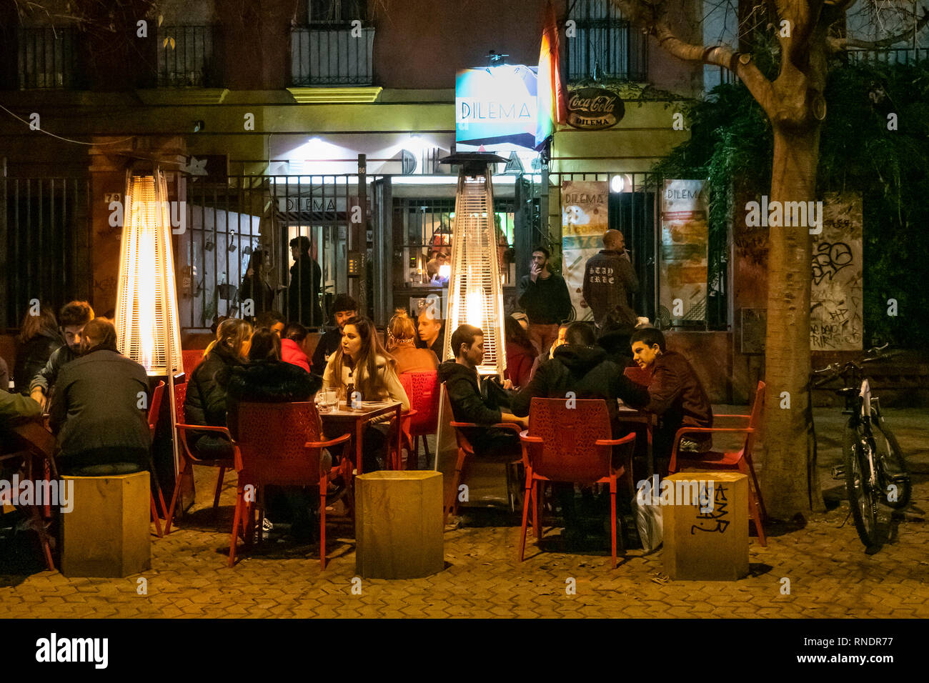 People having food and drinks at an outdoor cafe in the Alameda de Hercules in Seville, Spain Stock Photo