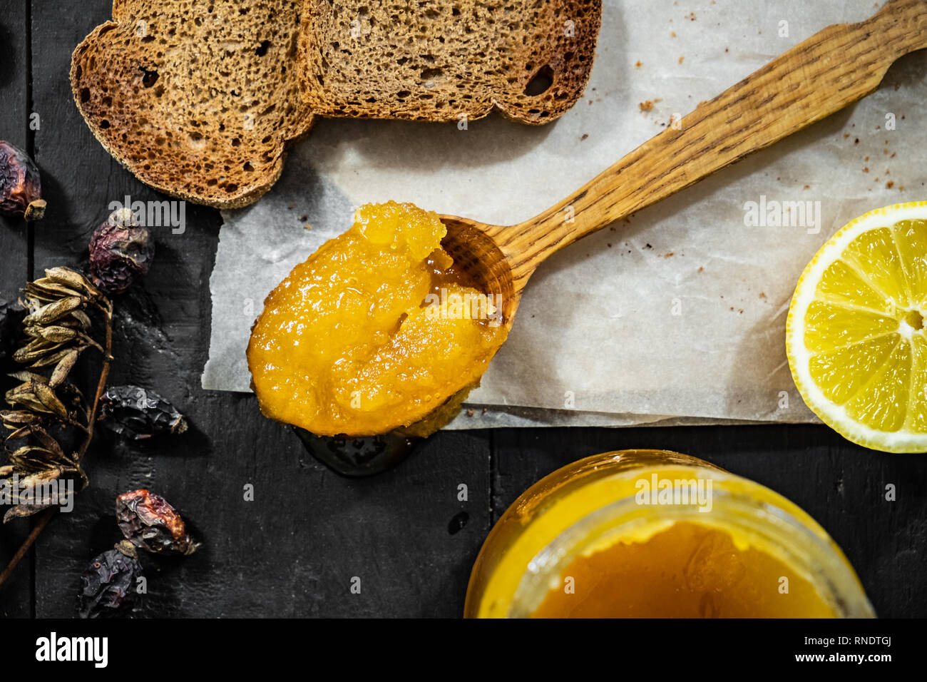 Spoonful of honey on dark rustic background, top view. Flat lay of crystallized home-made honey, low-key shot Stock Photo