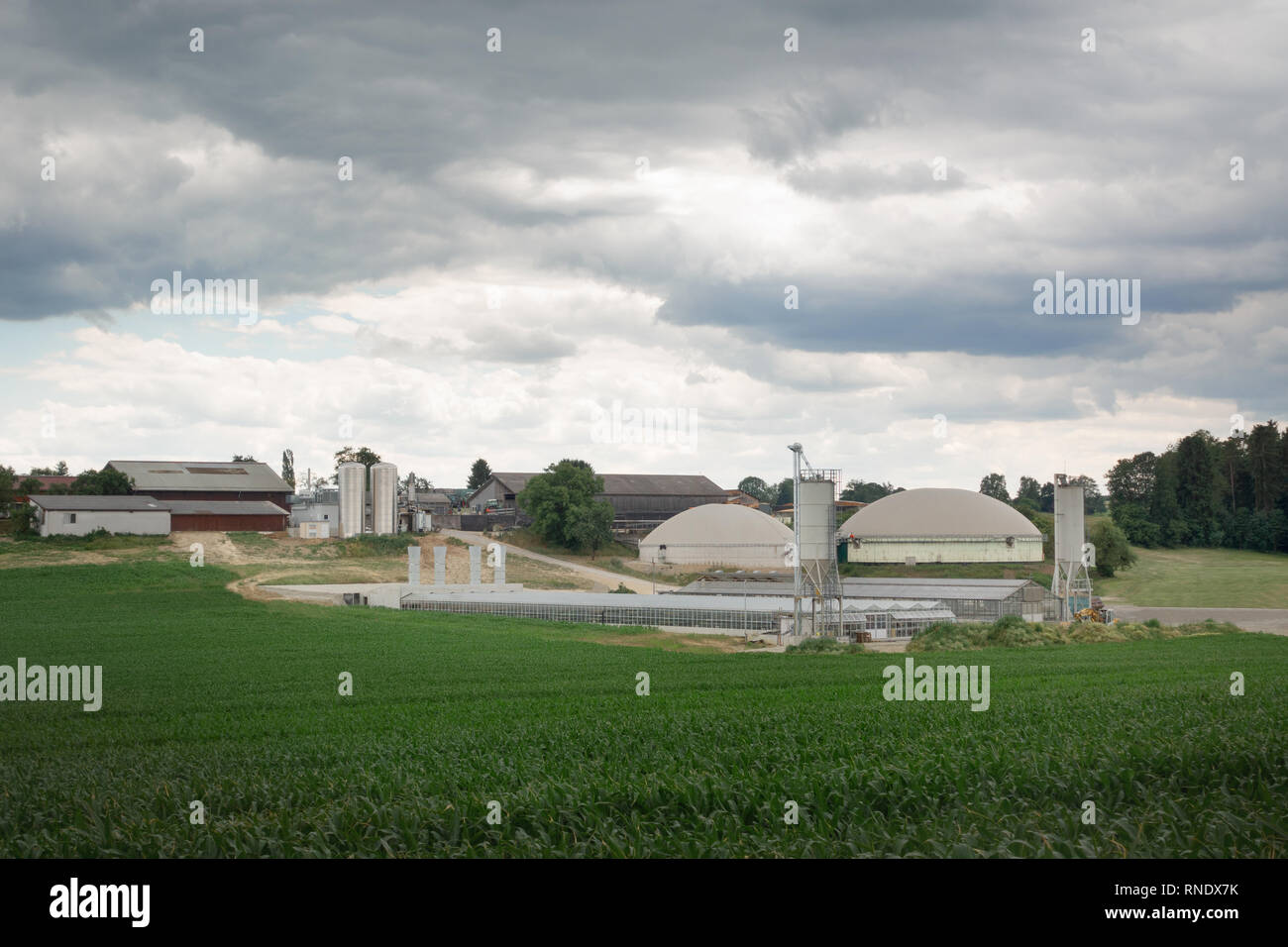 Dark clouds over a farm with biogas plant Stock Photo