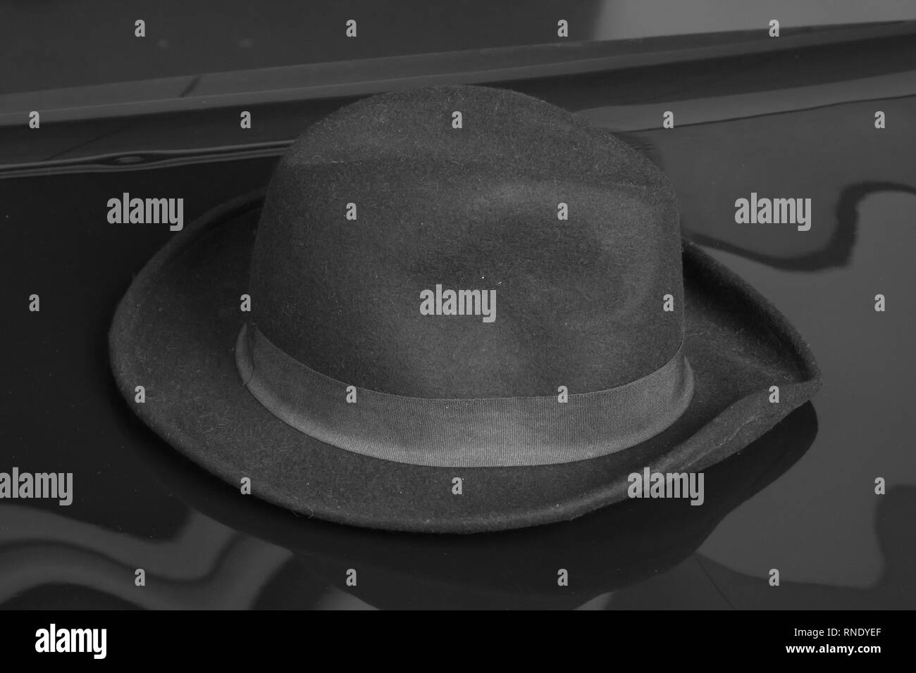 Old black hat on the black background. Stock Photo