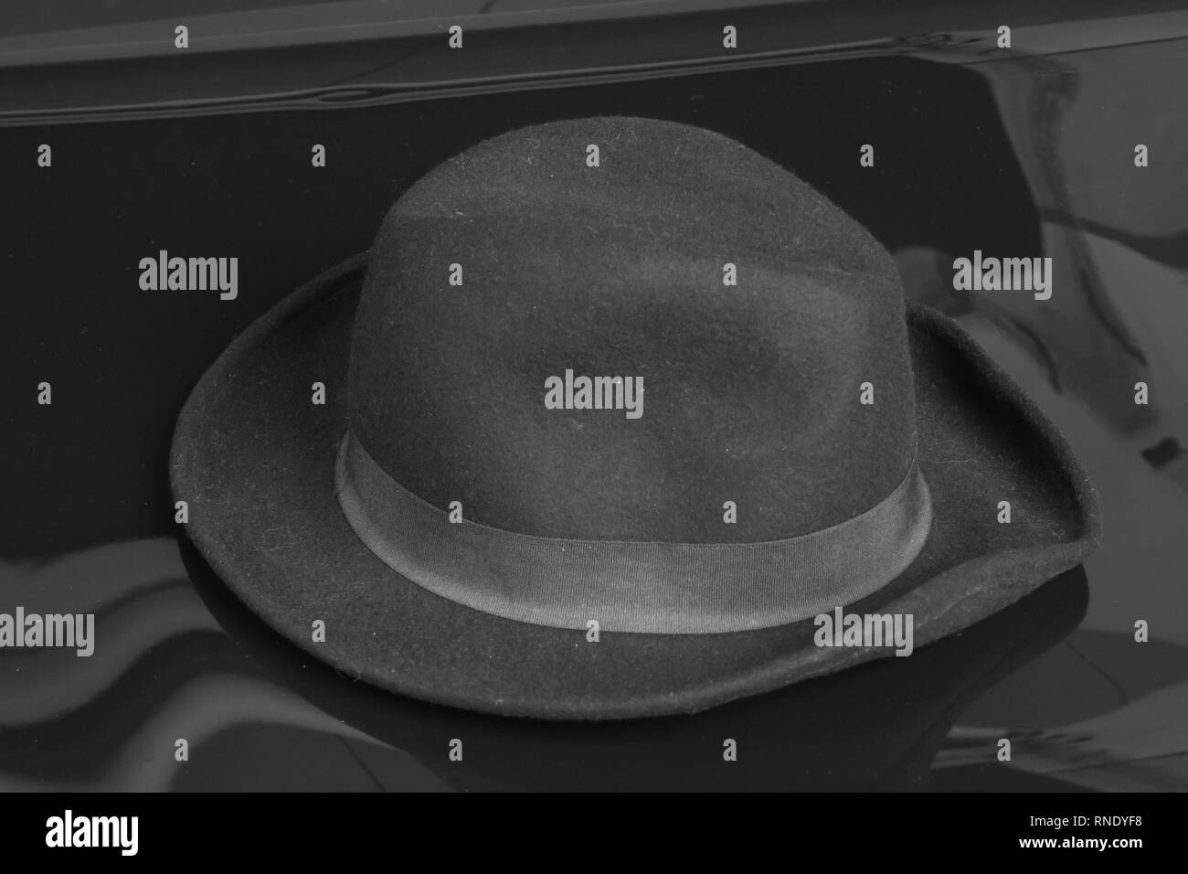 Old black hat on the black background. Stock Photo