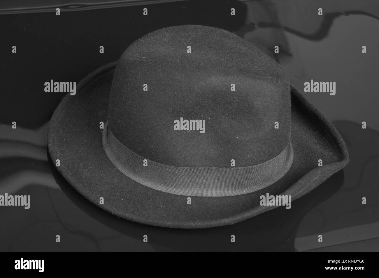 Old black hat on the black background. Stock Photo