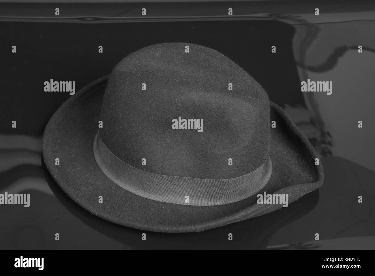 Old black hat on the black background. Stock Photo