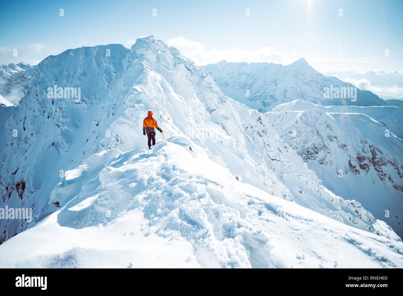 A climber ascending a mountain in winter Stock Photo