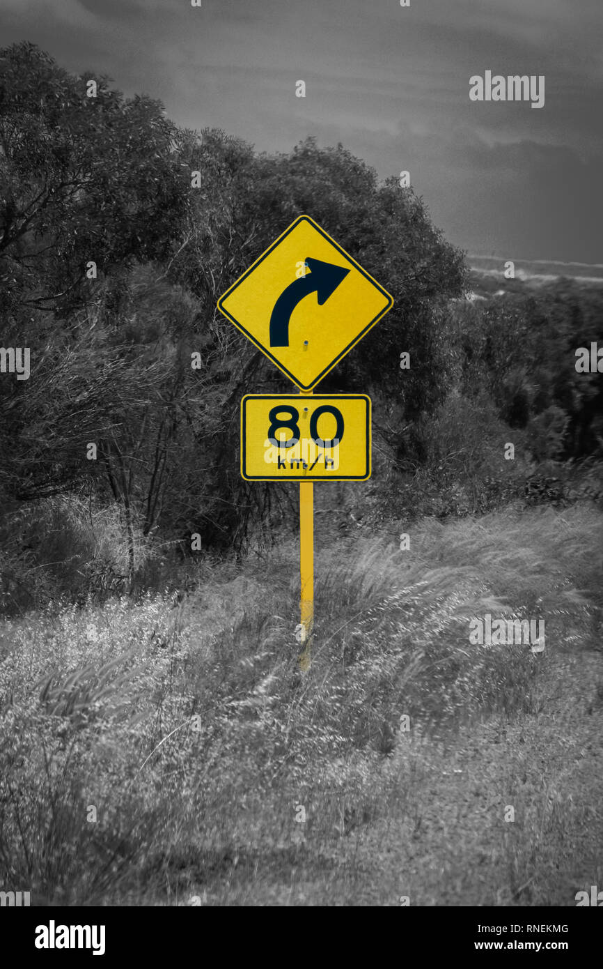 A black and yellow diamond shaped slight bend or curve right ahead road  sign Stock Photo - Alamy