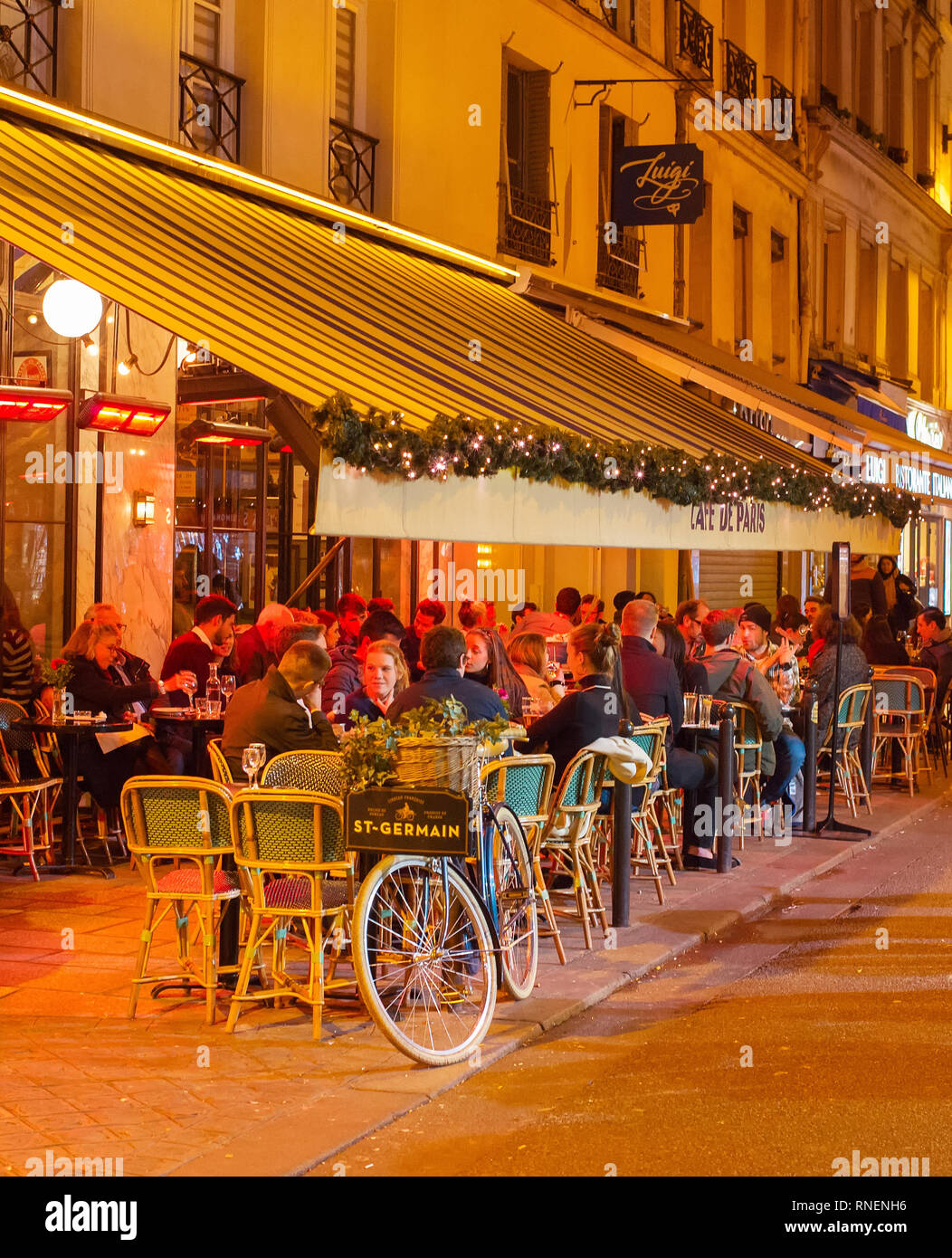PARIS, FRANCE - NOVEMBER 09, 2018: People at a street restaurant in Paris at night. Paris is the most visited city in Europe Stock Photo