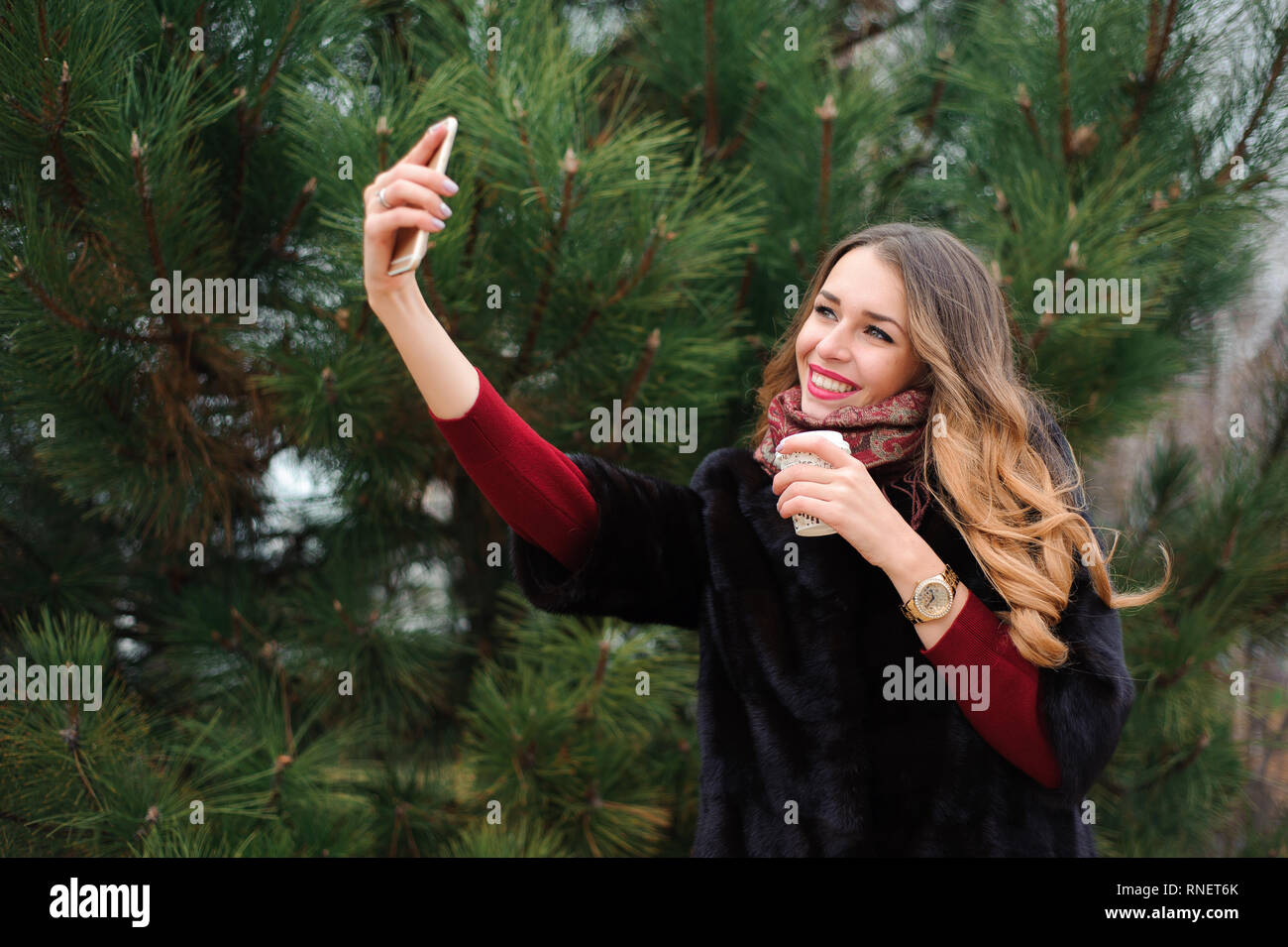 Beautiful girl doing selfie in autumn park Stock Photo