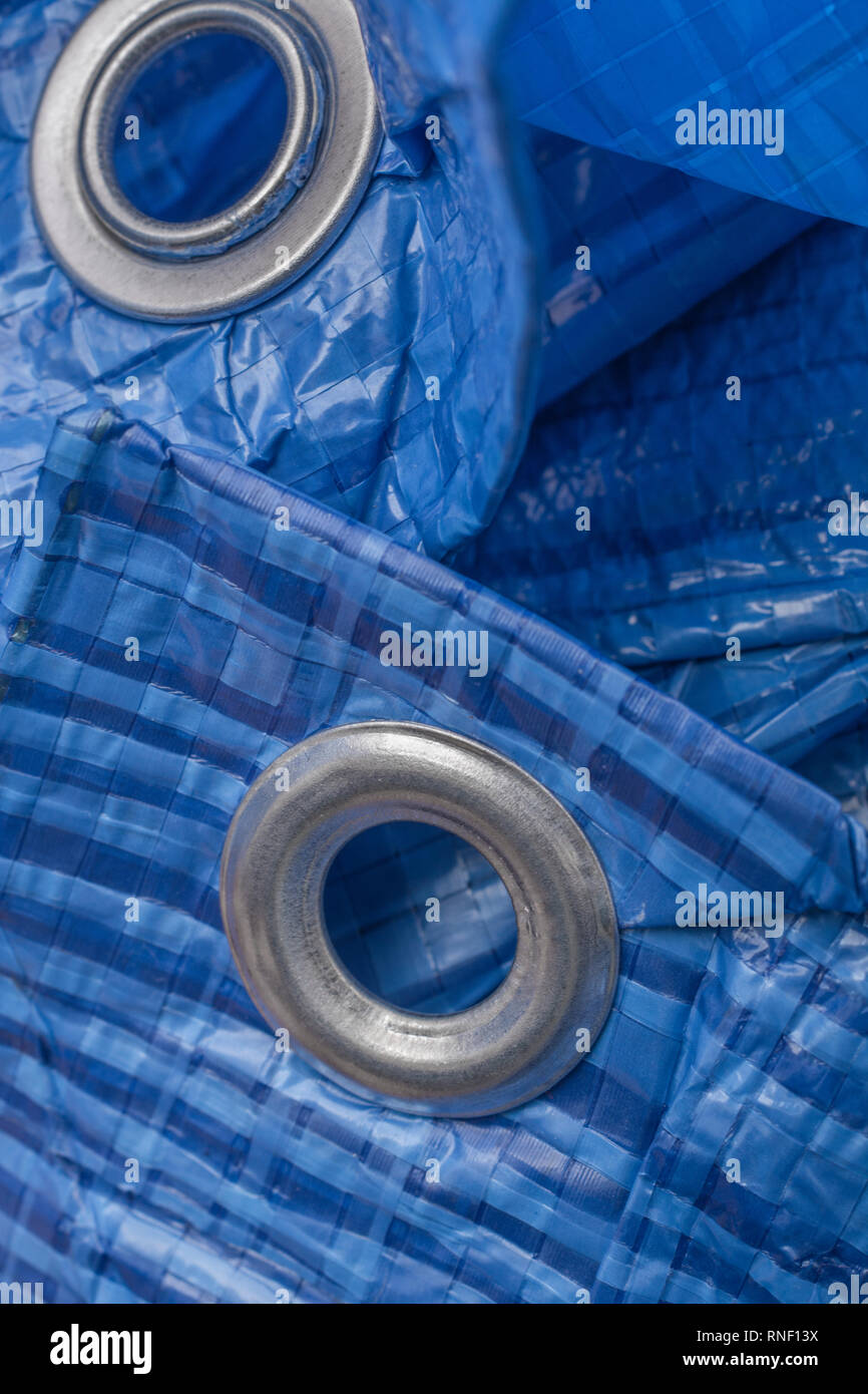 Blue LDPE protective tarpaulin / plastic tarp with aluminium eyelet.  Metaphor 'protection', building industry, protective layer metaphor Stock  Photo - Alamy
