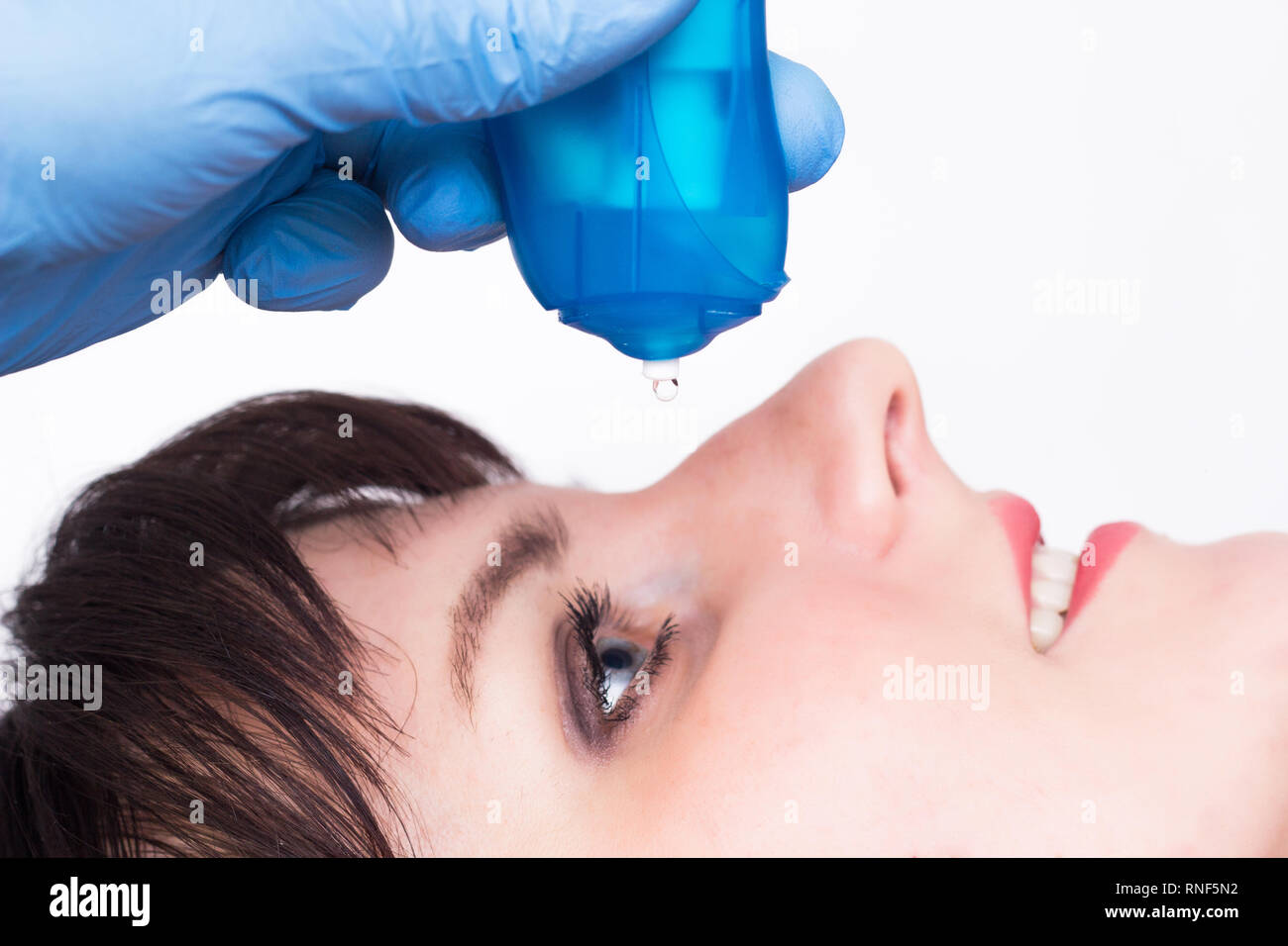 doctor buries moisturizing and vasoconstrictor eye drops to a caucasian