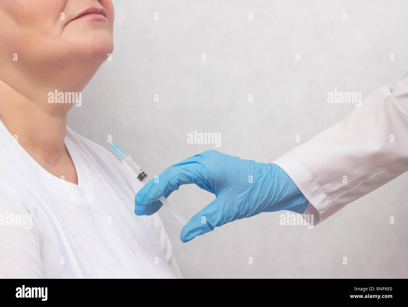 The doctor makes the woman puncture the thyroid gland to clarify the diagnosis, cancer, copy space, hypothyroidism, fine needle biopsy Stock Photo