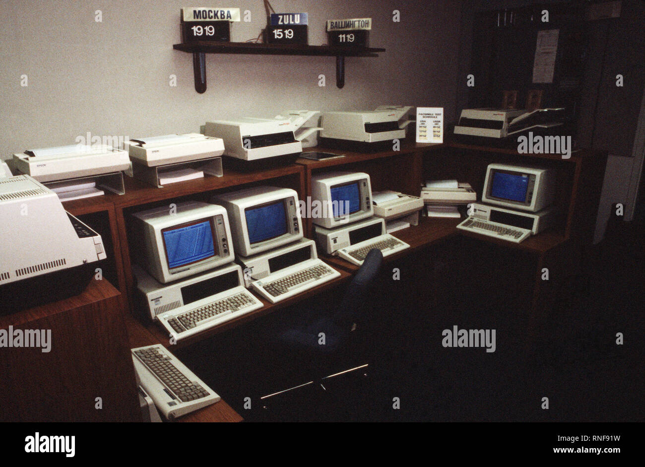 A view of computer stations, printers and facsimile machines that are part of American terminus of the Washington-Moscow Direct Communications Link.  Clocks on the wall give Moscow, Greenwich Mean (Zulu) and local times; a regular facsimile machine test schedule is at right.  The link was established by the US and Soviet governments in 1963 to ensure open lines of communication during potential crisis situations and reduce the risk of accidental war. Stock Photo