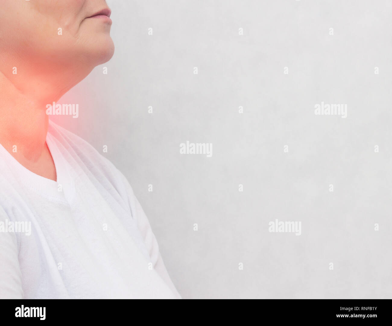 Adult woman who has problems with the thyroid gland, pain, nodes in the thyroid gland, white background, copy space, endocrine system, medicine, disea Stock Photo