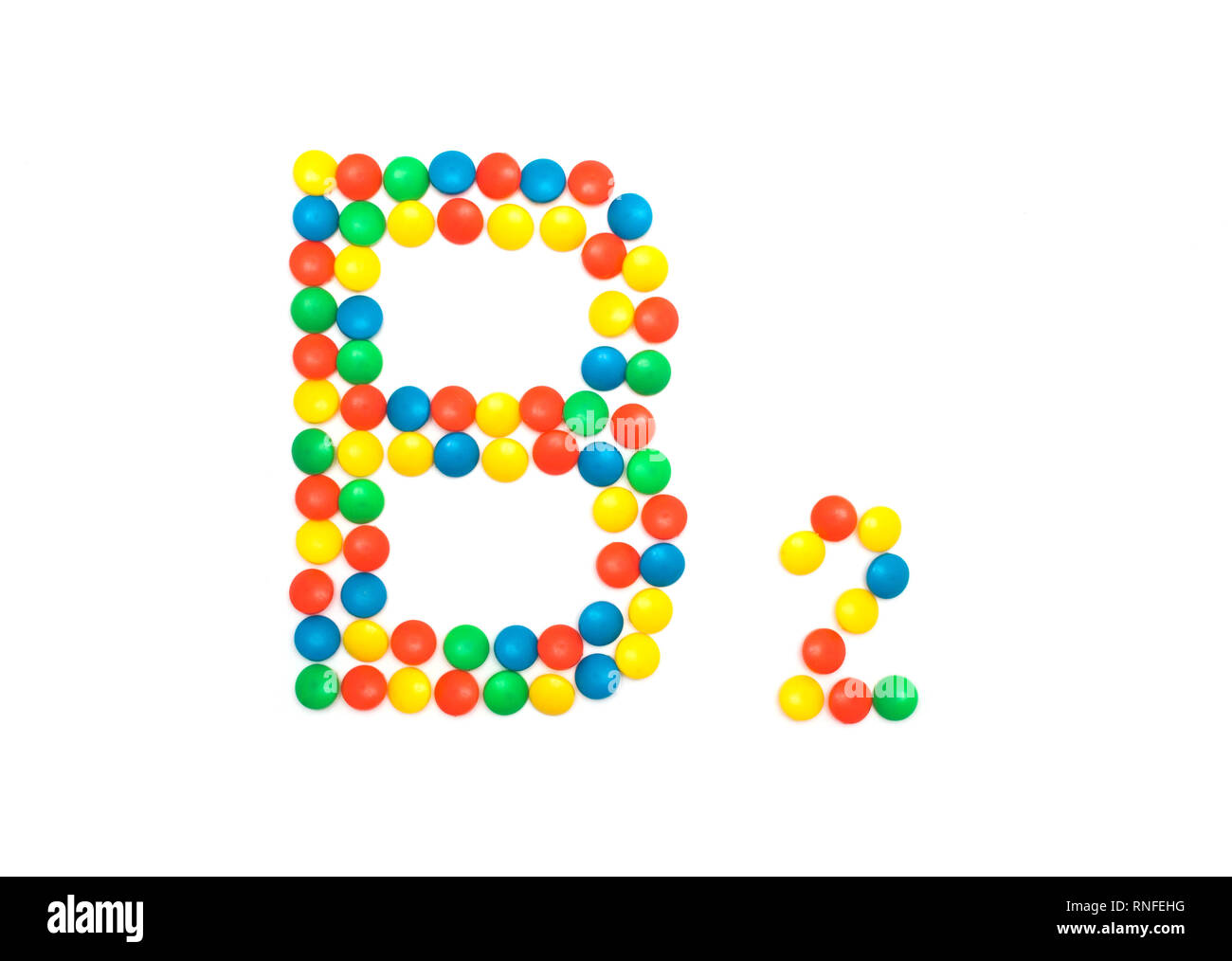 Multicolored vitamins pills that are lined with the letter Vitamin B2