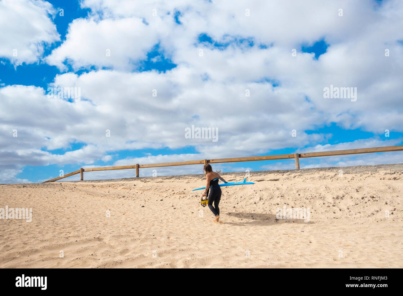 Female surfer on El Burro beach, Corralejo, Fuerteventura, Canary Islands, Spain. Stock Photo
