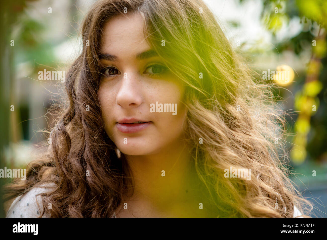 Young, beautiful, dark-haired woman portrait in the city park in the spring. Stock Photo