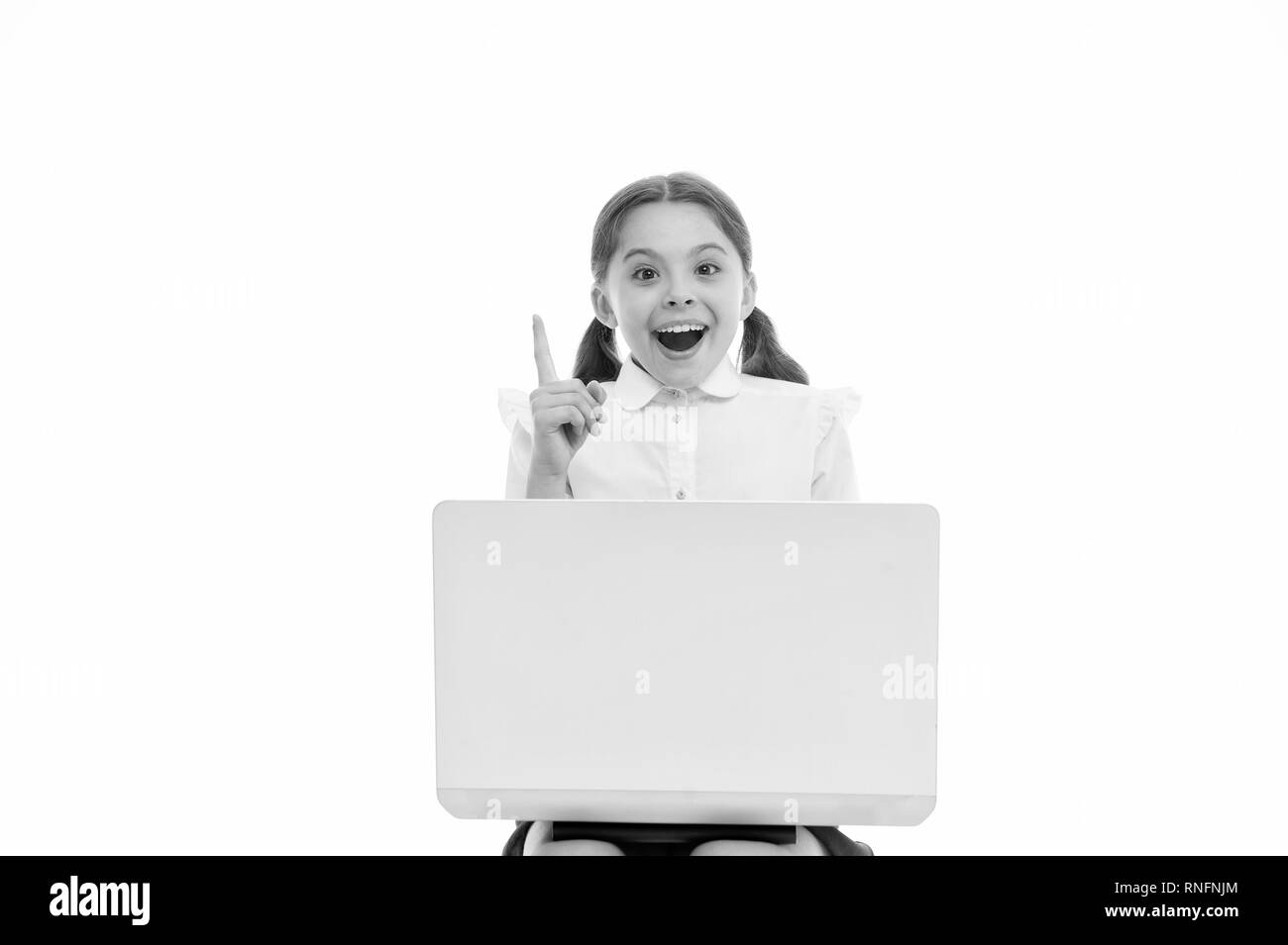Kid point finger up isolated white. Schoolgirl with laptop pointing upwards. Schoolgirl having idea or recommend check this out. This direction. Subscribe or check. Push button turn on notification. Stock Photo