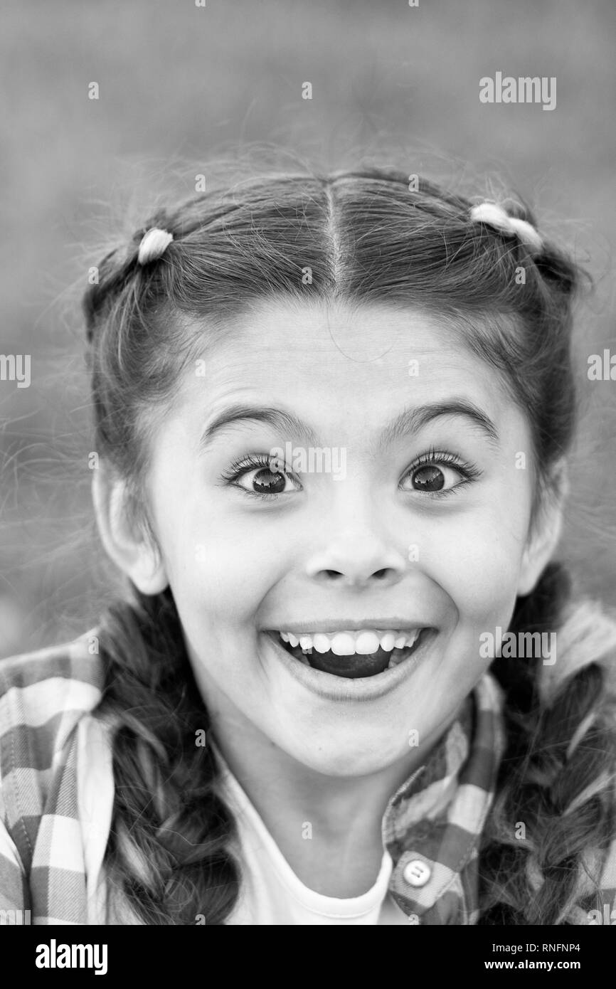 Cute surprised girl with smile on her face. Expression of happiness. Moment of unexpectancy. Looking forward to present. Beautiful young face. Bright emotion on lady face. Stock Photo