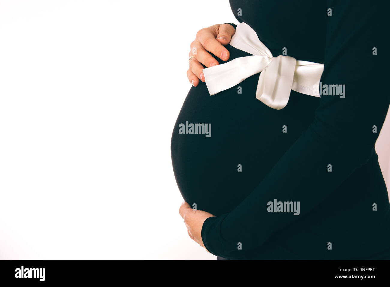 Pregnant Woman in Black Dress Holding Belly Closeup Stock Photo