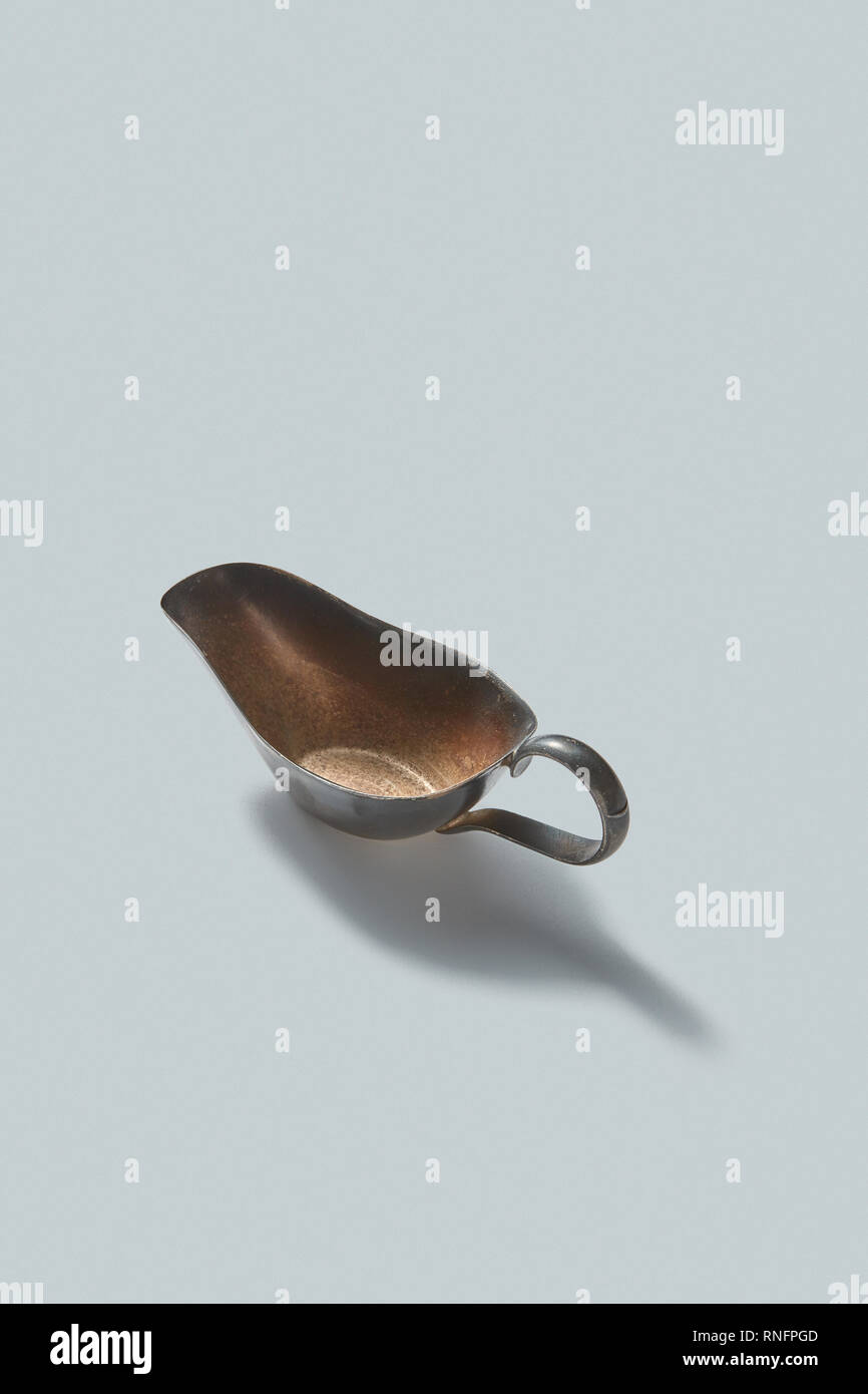 Vintage retro steel empty gravy boat on a white background with shadows, place for text. Stock Photo