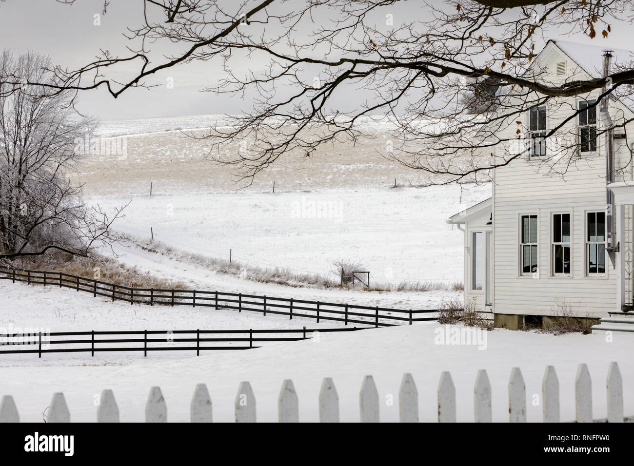 Farmhouse and fences against snow, Otsego County, New York State, USA Stock Photo
