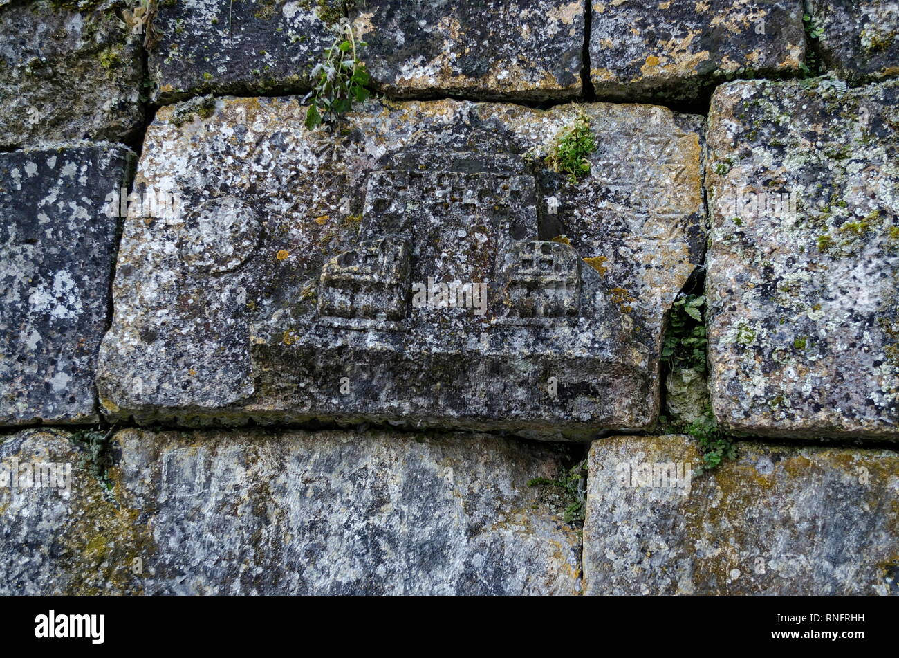 Part of the stone fence with ancient ritual stones and frescoes in Demir Baba Teke, cult monument honored by both Christians and Muslims in winter Stock Photo