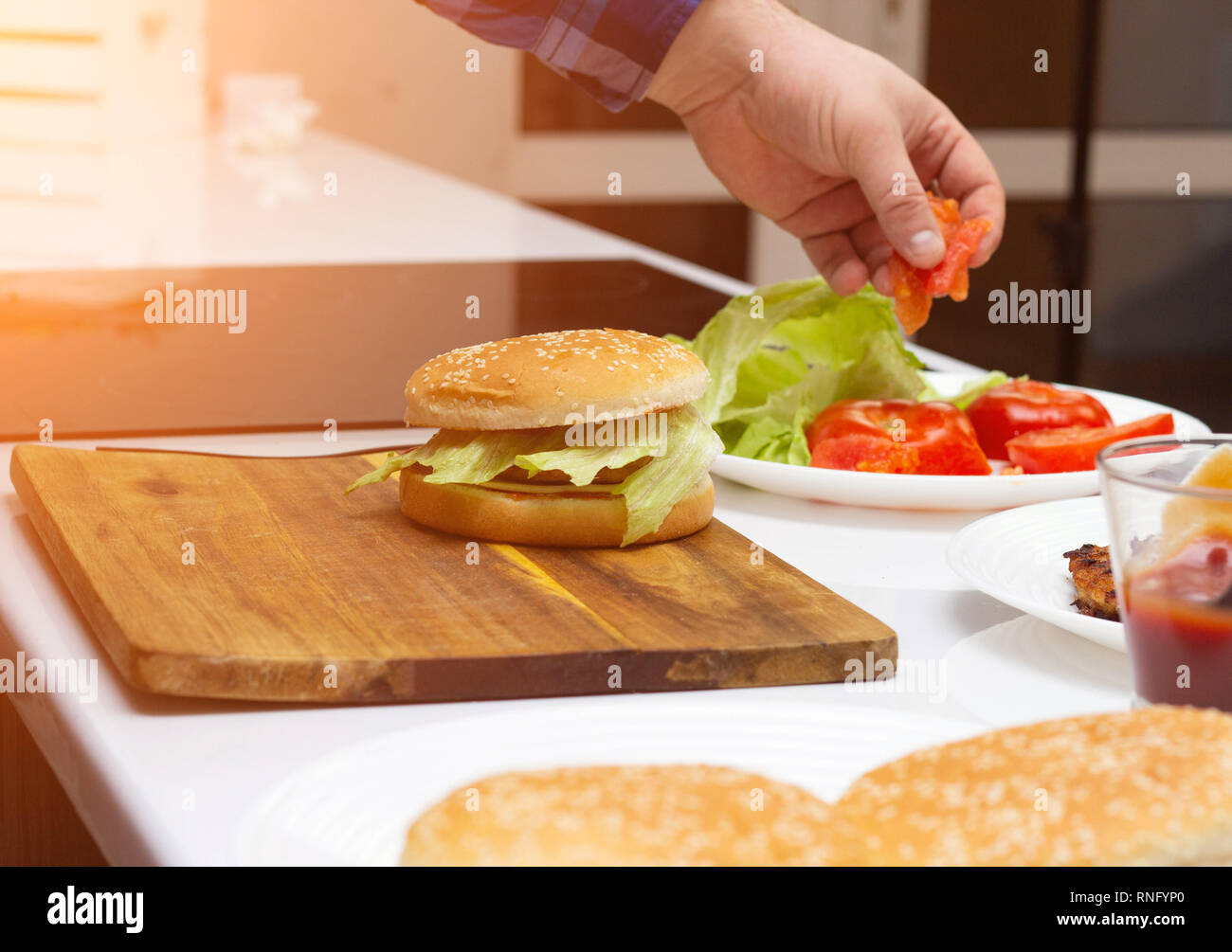 A man is preparing a fast food hamburger in a modern kitchen ...