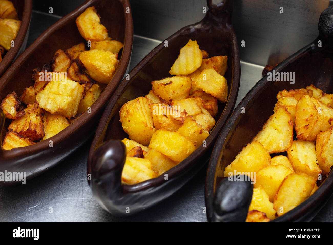 Restaurant dish of a boat with potatoes in a golden crust fried in a deep fryer. close-up, cholesterol Stock Photo
