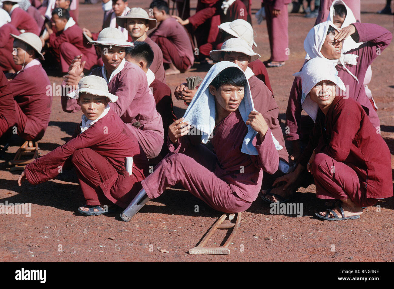 Viet Cong POWs, with caps and towels to protect from the sun, sit at the exchange location.  They were flown in on USAF C-130 aircraft from Bien Hoa Air Base.  They will be exchanged for American and South Vietnamese POWs held by the Viet Cong forces. Stock Photo